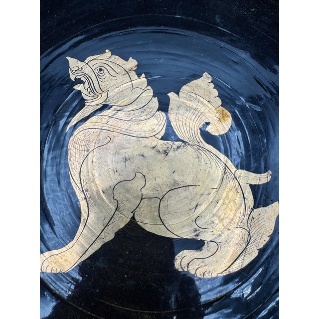 This vintage Burmese lacquer bowl features a hand-painted Chinthe, a mythical lion-like guardian figure traditionally...