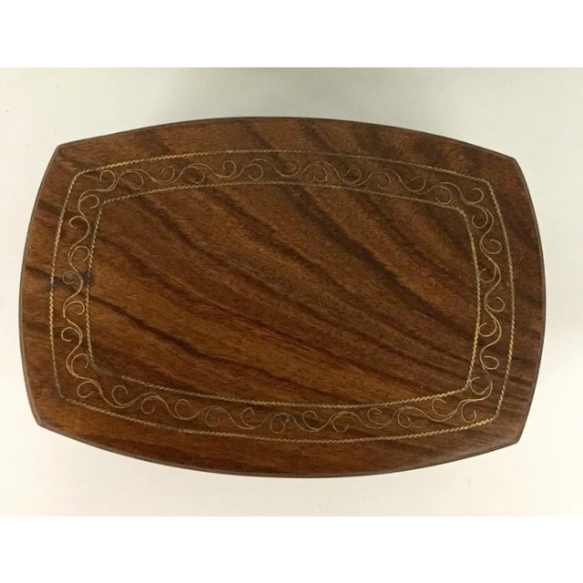 Wonderful hand carved box made of exotic wood from India. Complete with inlaid brass accent on the lid. The lid fits tight...