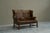 Highly Original Tufted English Wingback Settee in Patinated Leather England Early 20th Century A handsome and rare English...