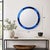Striking round wall mirror featuring a rich cobalt blue glass surround accented with polished metal details. The segmented...