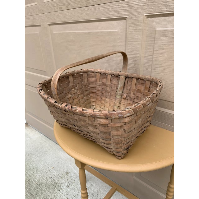 A beautifully woven early 20th century American splint oak basket with warm honeyed tones and a tightly constructed...
