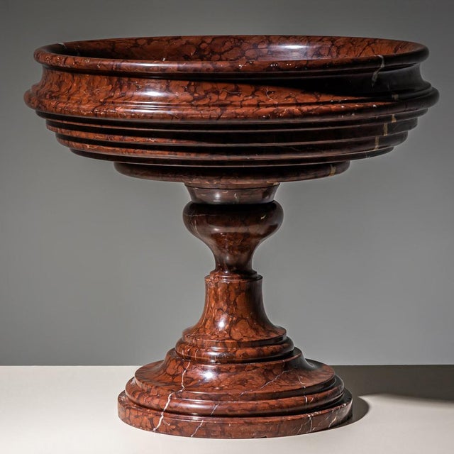 Classical dark red marble tazza with white veining, featuring a round baluster foot and a multi-profiled bowl. The piece...