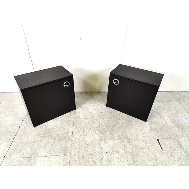 Pair of black wooden seventies bedside cabinets. The cabinets have cool handles. 1970s - Belgium Good condition...