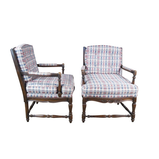 Two vintage French Country style arm chairs. Made of walnut featuring a ladderback design with carved floral and turned...