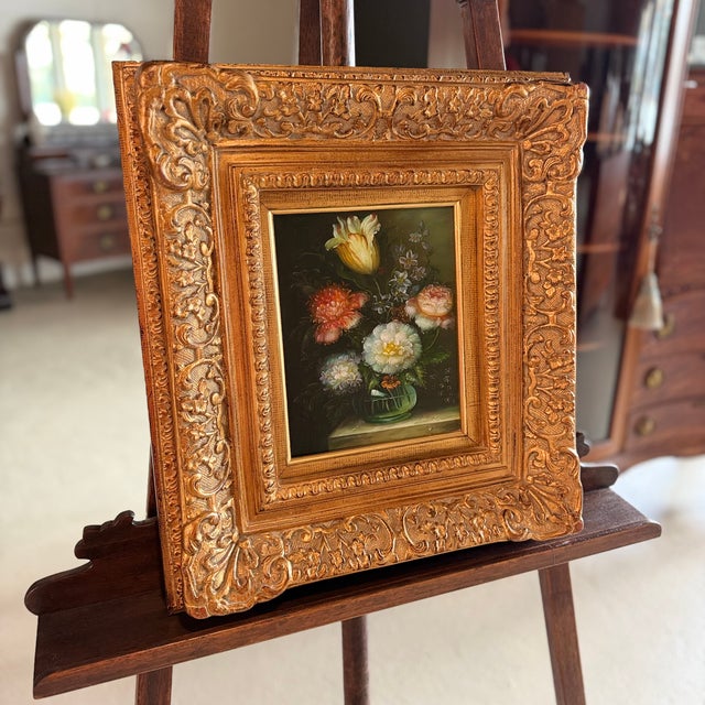 Framed, signed oil on canvas still-life painting depicting floral blooms in a vase. Lovely color and composition. Gold...