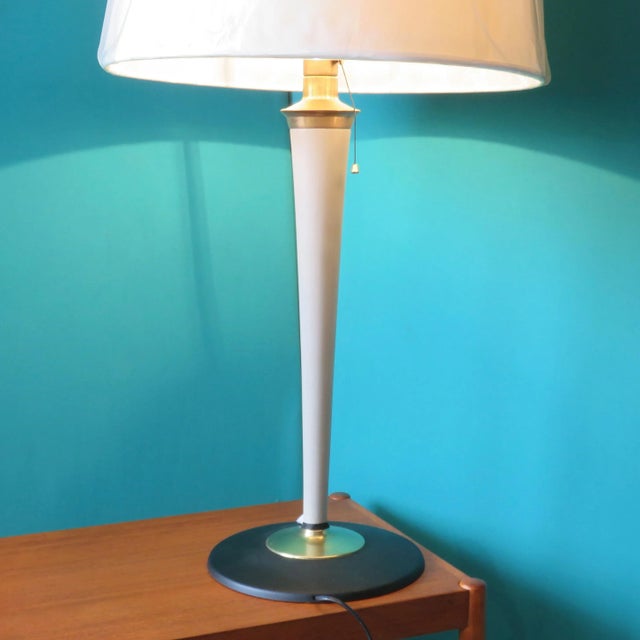 This lamp is made of gray-beige painted wood on a round cast iron base decorated with a brass washer. It is an elegant...
