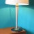 This lamp is made of gray-beige painted wood on a round cast iron base decorated with a brass washer. It is an elegant...