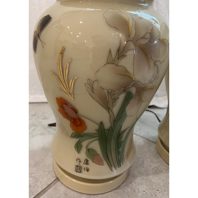 A beautiful pair of hand-painted vintage porcelain Chinese Ginger Jar Lamps. They have a cream background and are adorned...