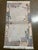 Hand-knotted Nepal wool rug featuring an open ivory field framed by a decorative border with stylized animal and abstract...
