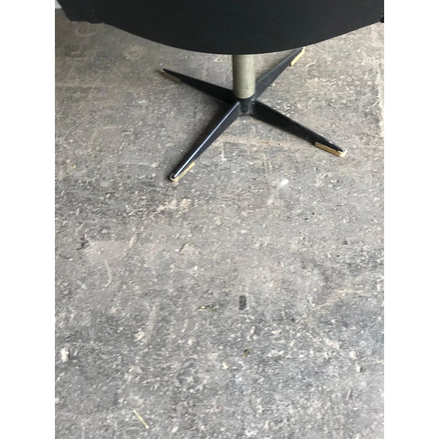 This chair has black leatherette upholstery and metal legs.