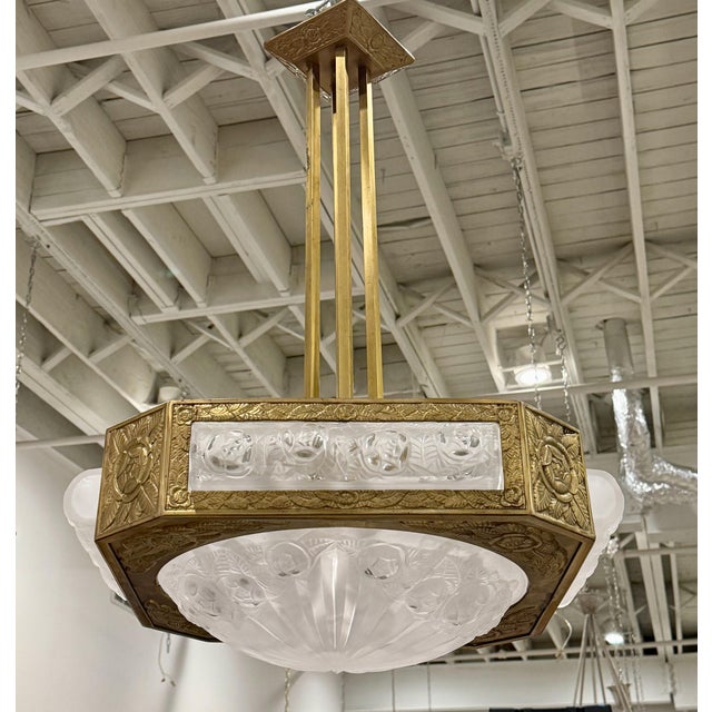 Stunning French Art Deco chandelier created by the French artist Degue. In a square brass frame embrace a center shade...