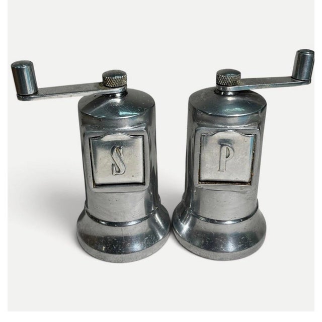 A handsome vintage Perfex salt and pepper mill set with classic cast-aluminum construction, hand-crank tops, and raised...