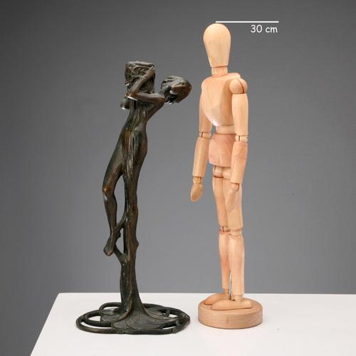 Bronze candle holder depicting a nymph with a basket. This piece is attributed to the mentioned designer/maker. It has no...