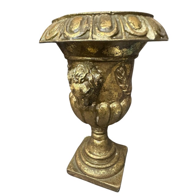 This item is a vintage-style decorative urn or planter, featuring gold-leaf detailing and ram's head handles. Similar...
