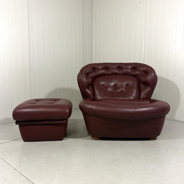 Lounge chair with footstool, France. Special round space age model in burgundy leather. 1970’s. In very good condition...