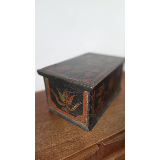 A wonderful 18th-century hand-painted folk art wooden box, beautifully decorated with bold stylised floral motifs in rich...