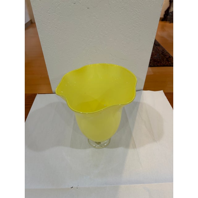 A vibrant hand-blown art-glass vase formed in opaque citron-yellow glass. The rounded body rises from a clear applied...