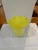 A vibrant hand-blown art-glass vase formed in opaque citron-yellow glass. The rounded body rises from a clear applied...