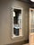 An oversized Hollywood Regency wall mirror featuring an architectural Greek Key frame with deep relief detailing. The...