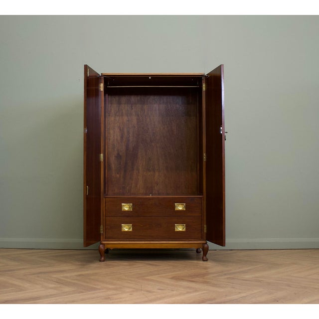 A superb quality compact wardrobe dating from the 1930s, featuring beautifully figured burr walnut doors with contrasting...