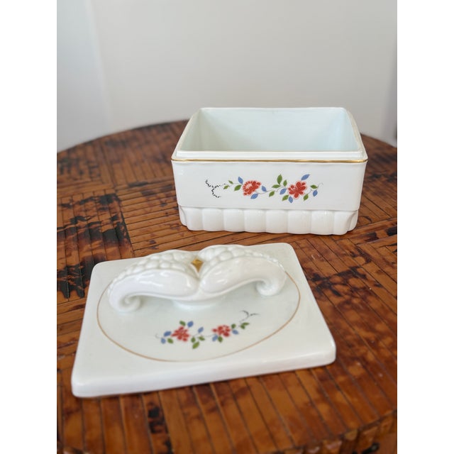 A beautifully detailed covered porcelain box by Meissen featuring a softly scalloped rectangular form accented with...