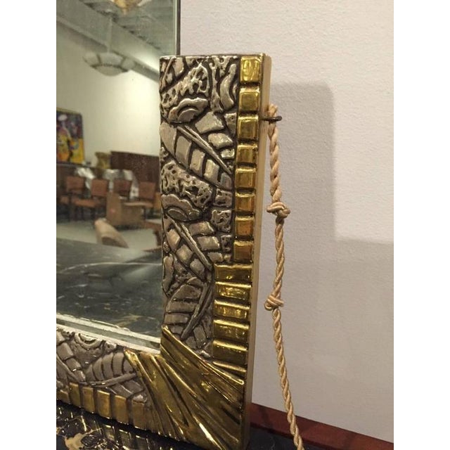 This late 1920s French Art Deco mirror sparkles. The frame, with its leaves and flower heads and geometric motif. The...