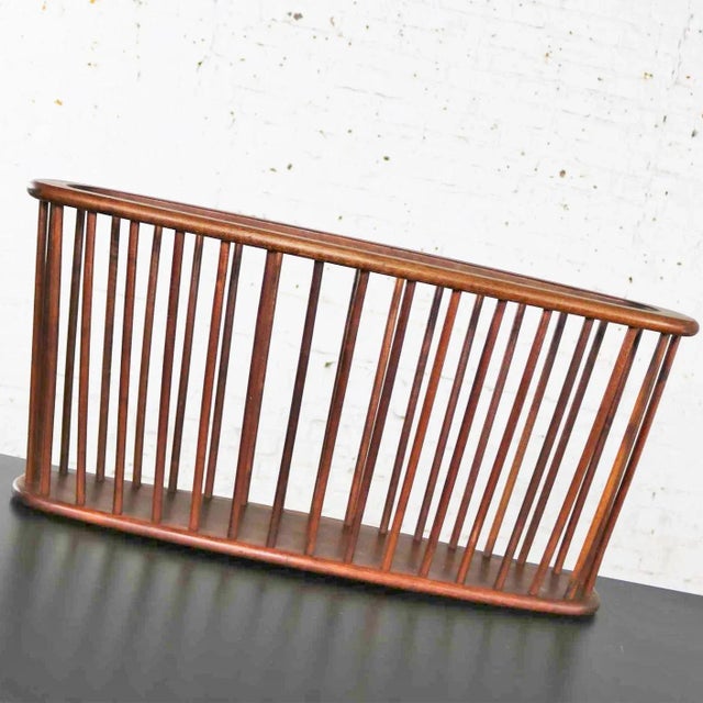 Handsome walnut oval magazine rack in the larger size attributed to Arthur Umanoff for Washington Woodcraft. It is in...