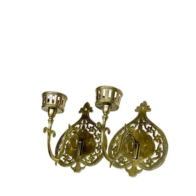 A brass 19th century wall candle holders A brass 19th century wall candle holders with a single arm. A candle holder with...