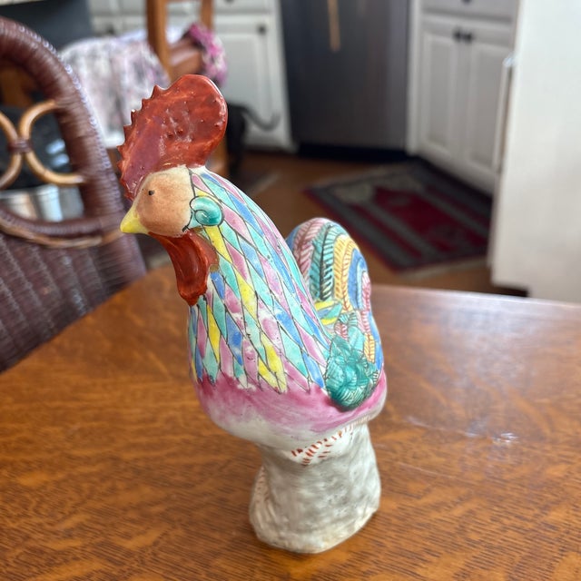 Famille Rose ( pink, blue, yellow, blue, and green hand painted feathers) export porcelain rooster figurine that by the...