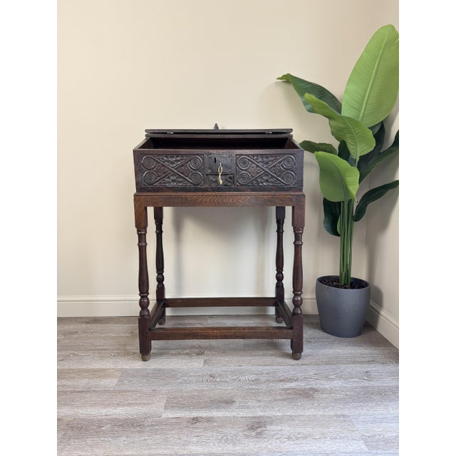 This beautiful and unusual piece is an antique carved oak bible box or writing box, upon a stand. These boxes were...