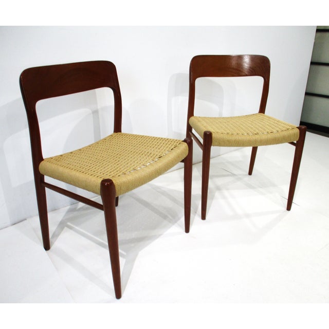 A pair of elegant classic Danish modern teak framed side chairs with sculptural back rails and woven seat bottoms. Sturdy...