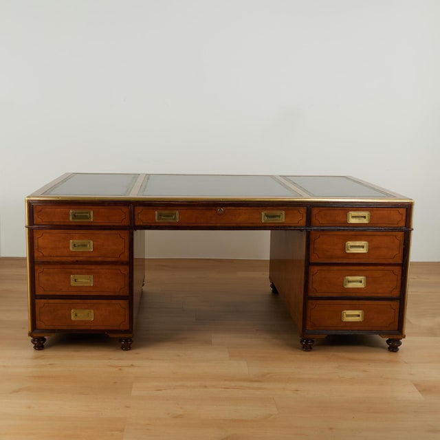 Impressive vintage partners desk crafted in satinwood and mahogany, featuring three tooled leather panels on a brass...