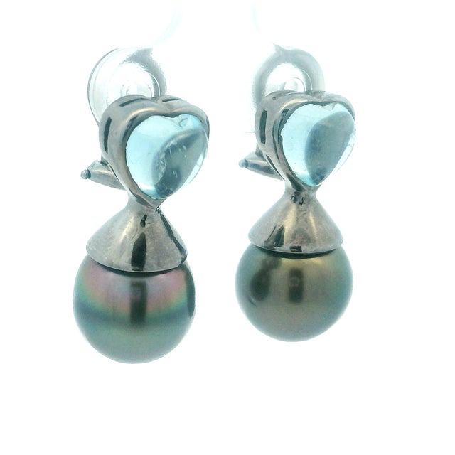 An exquisite pair of 18K gold earrings featuring luminous heart-shaped aquamarines totaling 3.50 carats, beautifully...