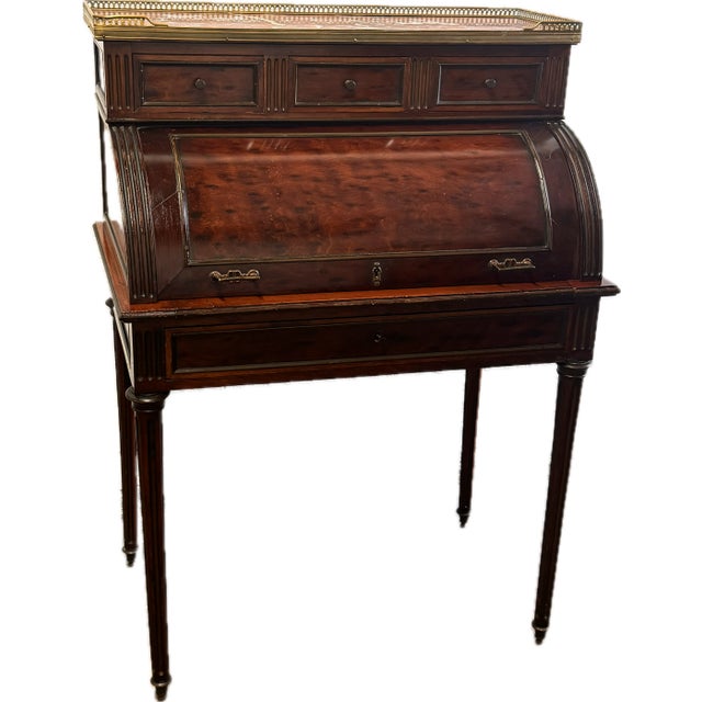 French Louis XVI style roll top desk with pierced brass gallery and chocolate marble top over three drawers. The roll top...