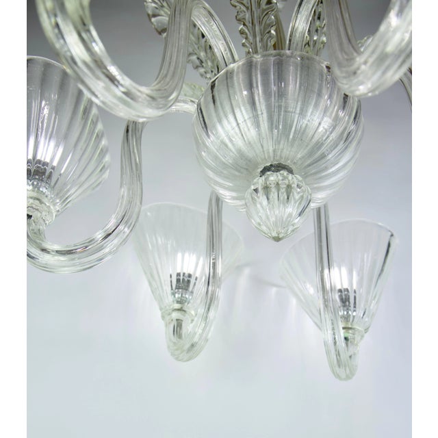 Italian Venetian Murano 1940s style (modern) clear glass chandelier with six fluted scroll arms supporting a large bowl...
