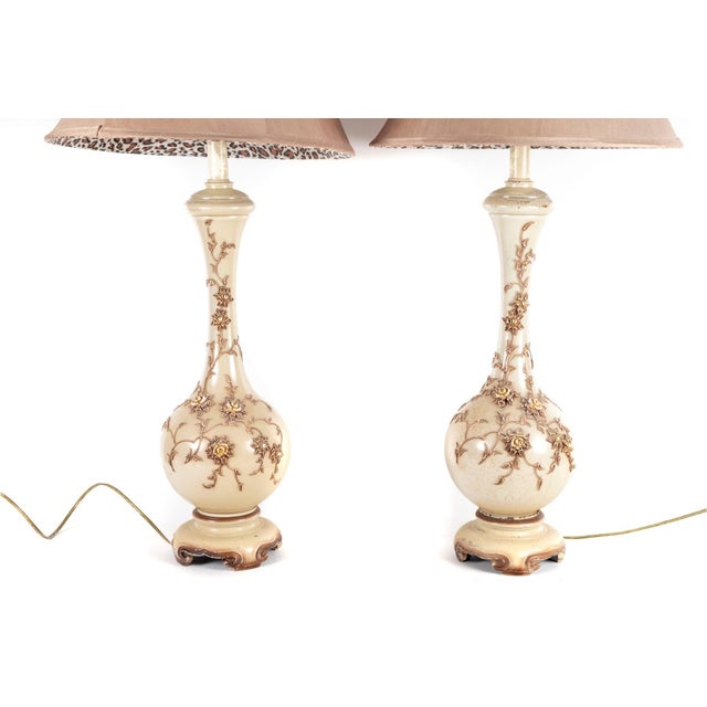 A dramatic and highly decorative pair of monumental Hollywood Regency table lamps. Each lamp features an elegant,...