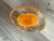 Murano blown glass style paperweight. Clear with an orange center
