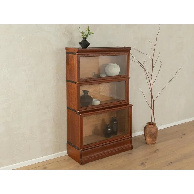 Wonderful modular antique bookcase from the 1900s. High-quality three-part cabinet made of dark-stained oak with...
