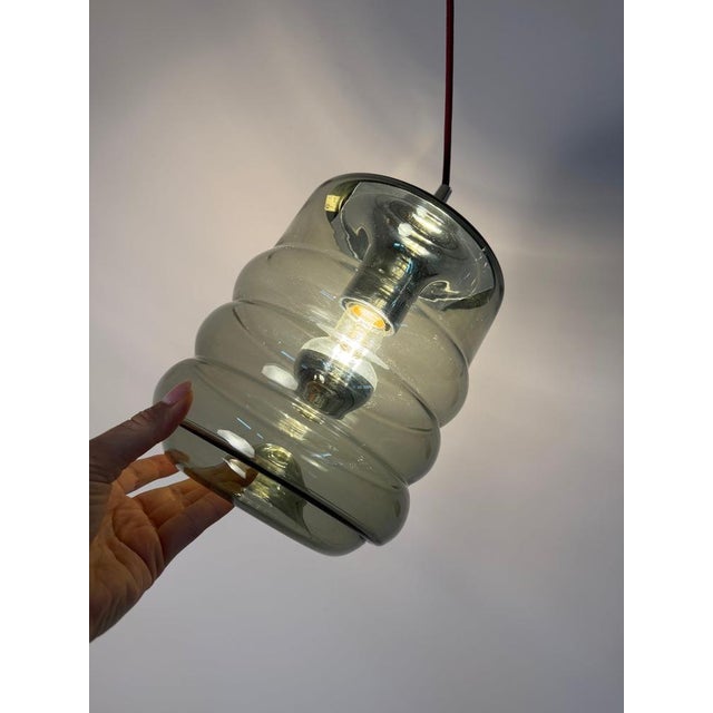 A masterpiece of german space-age design: this pendant lamp from peill & putzler, crafted from smoked glass and chrome,...