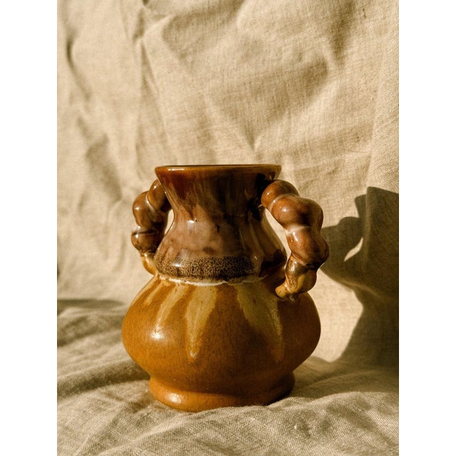 A solid, earthy piece, straight from the kilns of French ceramic tradition. The robust body is enveloped in a runny glaze...