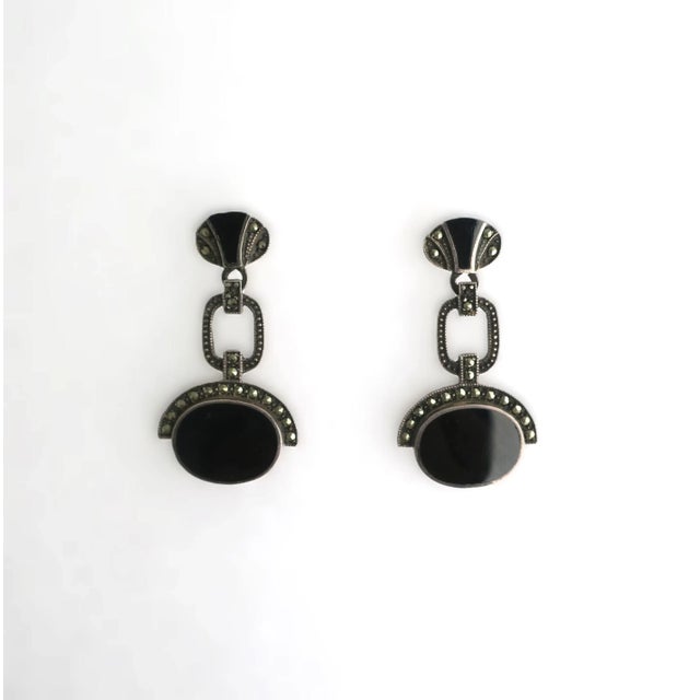 This is part of Chairish’s Fine Jewelry assortment. A beautiful pair of black onyx and sterling silver Art Deco style...