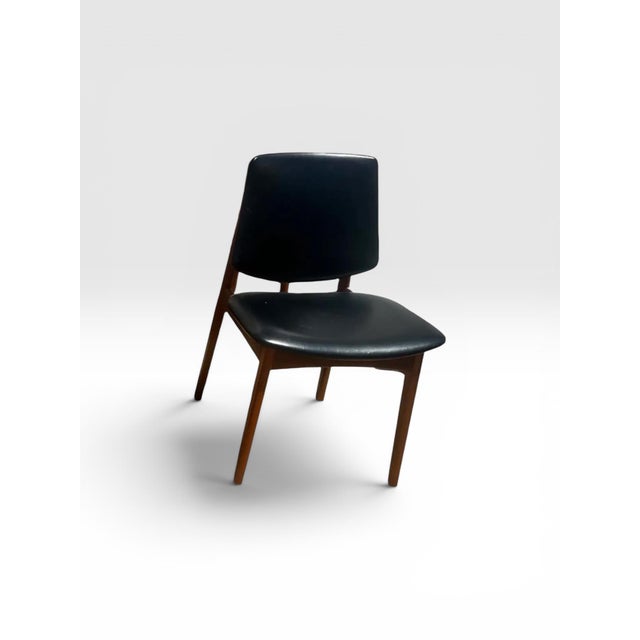 A handsome pair of authentic Danish Modern dining chairs crafted in warm solid teak and retaining their original black...
