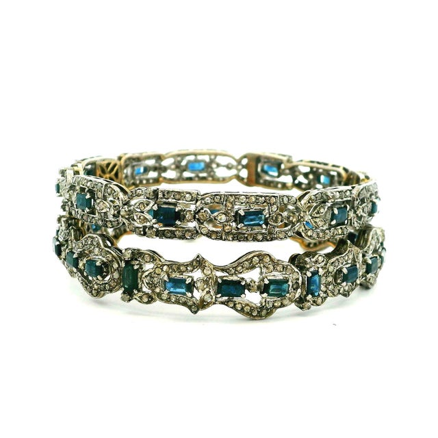 An exceptional pair of vintage Indian bracelets handcrafted in silver over 14 karat gold, showcasing the rich gemstone...