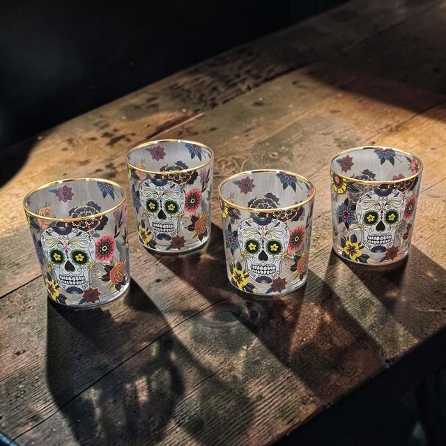 The set of four Williams-Sonoma Day of the Dead painted tumblers highball glasses is a vibrant and eye-catching addition...