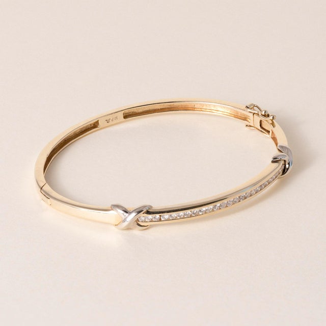 Vintage 14K Gold Diamond X-Motif Bangle Bracelet Circa 1990 This vintage solid 14K gold bangle showcases a striking...
