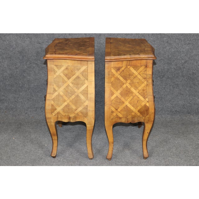 A striking and highly decorative pair of Italian bombe parquetry nightstands, masterfully crafted with elegant serpentine...