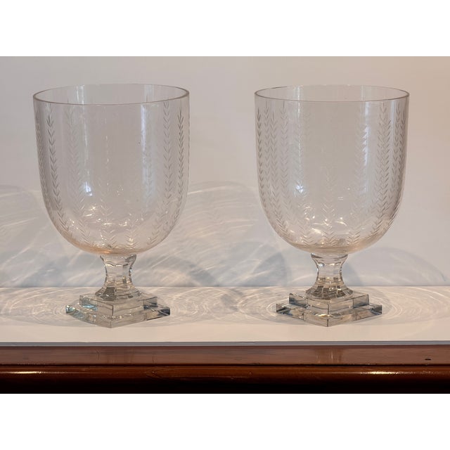 Pair of tall clear glass vases etched with a vertical wheat sheaf pattern. Each stands on a stepped square base and...