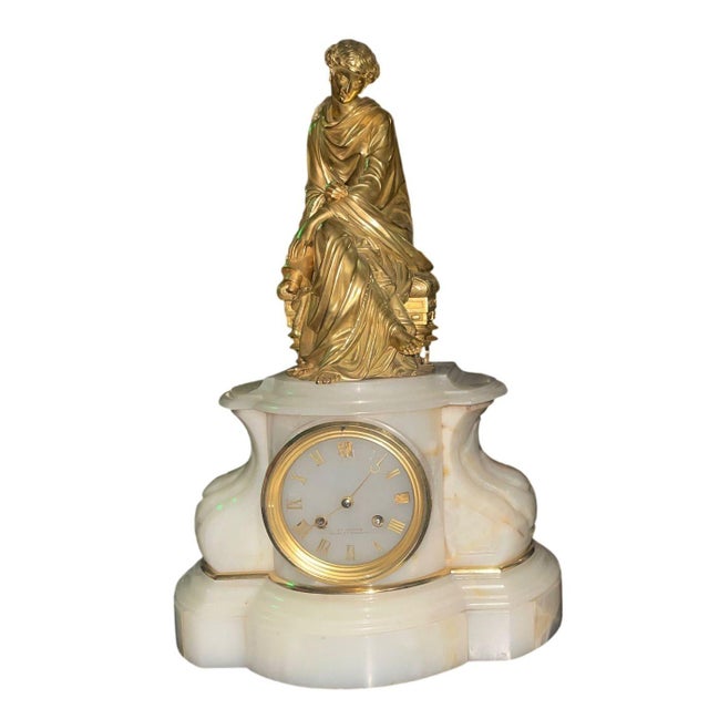 A superb Early 20th-century French gilt-bronze and onyx clock garniture, comprising a figural mantel clock and a matched...