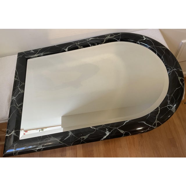 A striking 1980s Postmodern capsule wall mirror featuring a monumental arched profile. The frame boasts a brilliant,...