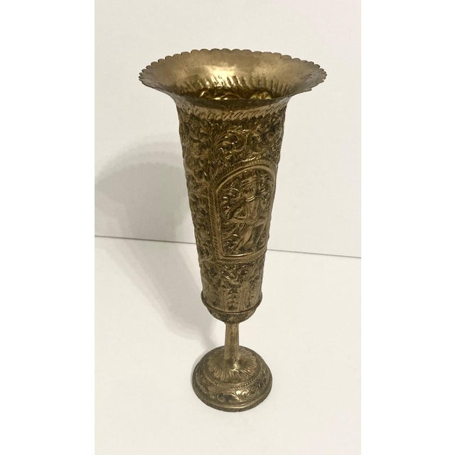 Anglo Indian brass vase showing a blend of two cultures. Detailed repousse' artwork forms the body which rests on a heavy...